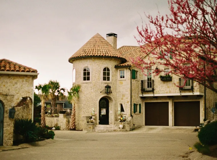 Stone house with a tiled roof, a turret and a two-car garage in Dallas
